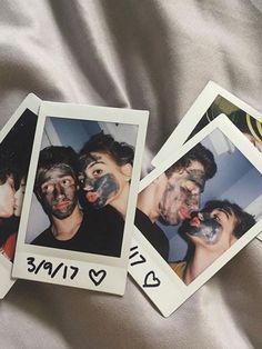 four polaroid photos with faces painted on them