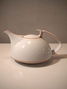 a white ceramic tea pot sitting on top of a table