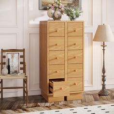 a tall wooden cabinet with drawers next to a chair and lamp on the side wall