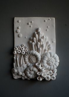 a white wall hanging with flowers on it