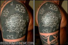 a man's arm covered in tattoos with flowers and leaves on the sleeve,