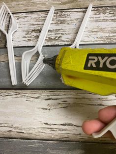 a person is using a drill to fix a piece of wood that has been painted white