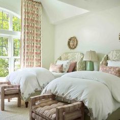 two beds in a bedroom with white linens and pink pillows on the headboard