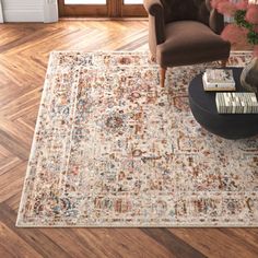 a living room with a large rug on the floor and a chair in front of it