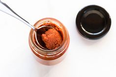 a jar filled with something next to a spoon