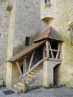 an old stone building with stairs leading up to it