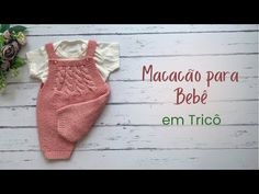 a baby's pink and white outfit next to flowers on a wooden background with the words macao para bebe em trico