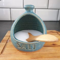 a wooden spoon in a blue ceramic salt container