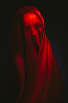 a woman in a red shawl with her head turned to the side and eyes closed