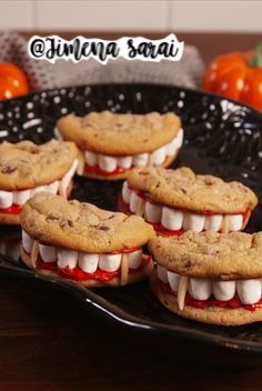 chocolate chip cookies with marshmallows and teeth are on a black platter