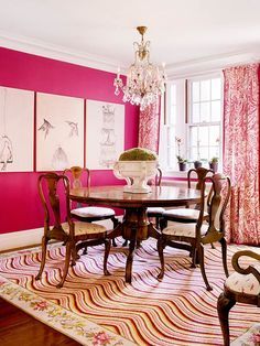 a dining room with pink walls and chairs