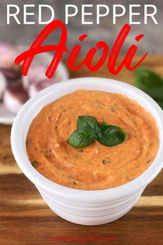 red pepper sauce in a white bowl with basil leaves on top and text overlay