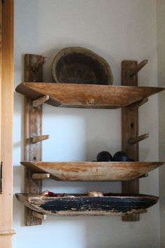 three wooden shelves are stacked on top of each other in a room with white walls