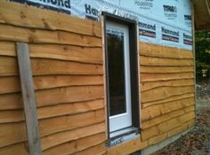 a house being built with wood siding and windows