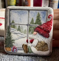 a hand painted glass block with a santa clause looking out the window at christmas trees