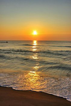 the sun is setting over the ocean with waves