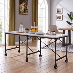 a dining room table with two chairs and a bowl of fruit on the table next to it