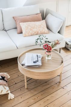 a living room with white couches and pink accents on the walls, along with an image of a coffee table