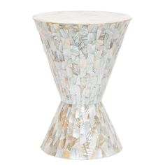 a white and gold vase sitting on top of a table next to a white wall