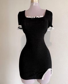 a mannequin is wearing a black dress with white ruffles on it