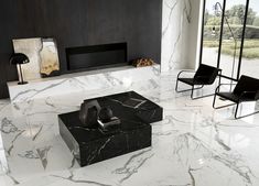 a black and white marble coffee table in front of a fireplace with two chairs next to it