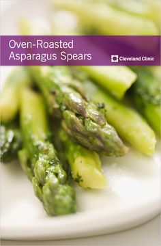 asparagus spears on a plate with lemon wedges