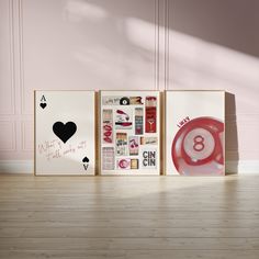 three cards with different designs on them in front of a pink wall and wooden floor