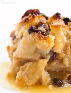 a piece of bread pudding with raisins and caramel sauce on a plate