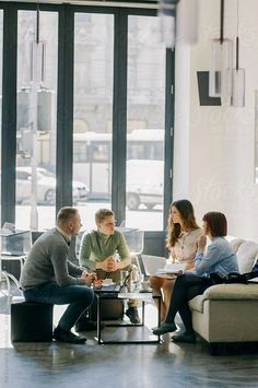 group of people sitting around a table with laptops