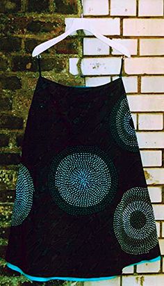 a black and blue dress hanging on a brick wall