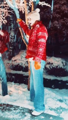 two men standing next to each other in the snow near a tree with no leaves on it