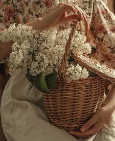 a woman holding a basket with flowers in it