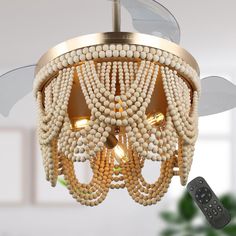 a chandelier made out of beads with a remote control in the foreground