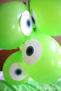 some green balloons with googly eyes on them