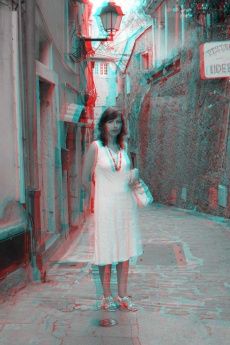 a woman in a white dress is standing on the street