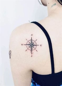 a woman's shoulder with a compass tattoo on it