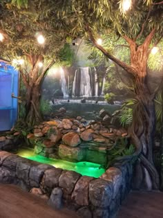 a room with a waterfall and lights on the wall, surrounded by rocks and trees