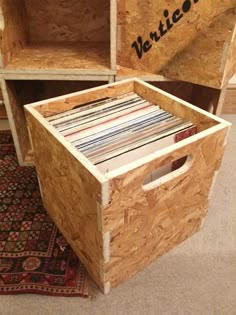 two plywood boxes with vinyl records in them sitting on the floor next to a rug