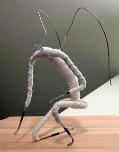 a sculpture made out of yarn sitting on top of a wooden table