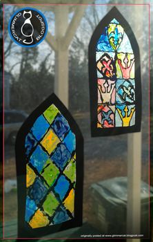 two stained glass windows sitting on top of a window sill in front of a tree