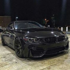 a black bmw is parked in the parking lot