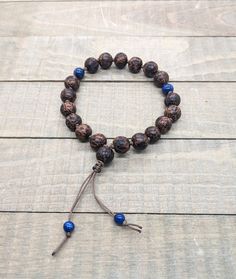 Beautiful, hand-knotted wrist mala featuring 10mm palm wood beads and Lapis Lazuli accents. This bracelet is made for larger wrists or those who like a looser fit (see measurements below). -Palm wood represents tenacity and resilience. It represents strength and flexibility in the face of adversity. -Lapis Lazuli is associated with self expression, inner truth, and emotional freedom. It is thought to alleviate headaches and boost the immune system. This bracelet contains the traditional 18 woode Palm Wood, Meditation Bracelet, Wrist Mala, Emotional Freedom, Macrame Knot, Yoga Jewelry, The Immune System, Beaded Dangles, Beads Bracelet