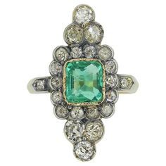 Here we have a classic navette ring dating back to the Victorian period. This antique piece showcases a single rectangular cushion cut emerald at the centre of the face surrounded by a vast silver set backdrop of round faceted old cut diamonds. Each stone has been set in a fine milgrain detailing, including the single stone at each shoulder. The piece is finally finished with a ribbed 18ct yellow gold band. Condition: Used (Very Good) Weight: 5.1 grams Ring Size: M 1/2 (54) Band Width: 2mm Face Dimensions: 28m x 12mm Emerald Dimensions: 7mm x 6.5mm (approx. 0.88ct) Total Diamond Weight: Approx. 1.30 carats Diamond Details: Colour: G-M, Clarity: VS-SI Tested As: 18ct Gold & Silver Period: Victorian Box: The Vintage Jeweller Ring Box Heirloom Green Rectangular Rings, Navette Ring, Rectangular Cushion, Victorian Period, Victorian Rings, Single Stone, La Face, Emerald Diamond, Ring Box