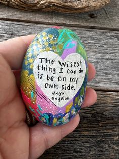 a hand holding a painted rock with the words, the wise thing i can do is be on my own side