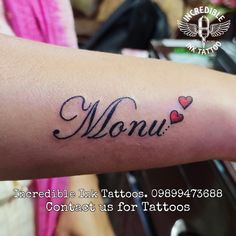 a woman's arm with the word mom tattooed on it and hearts in black ink