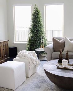 a living room filled with furniture and a christmas tree in the middle of the room