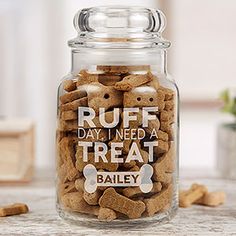 a glass jar filled with dog treats on top of a table