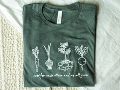 "This forest green heathered tee features hand drawn minimalistic root vegetables and the phrase \"root for each other and we all grow.\" It feels like a well-loved favorite from day one, and would make a perfect gift for the dietitian, vegan/vegetarian, or gardener in your life! DETAILS + Light weight cotton/poly blend for super soft feel + Tear away label + Runs true to size (see chart in listing photos) - size up for roomy fit + Pre-shrunk PRODUCTION + Design is screen printed + Shirts are pr Damian Leigh, Gardener Aesthetic Outfit, Farmstand Recipes, Vegetarian Gifts, Gardening Backyard, Farm Clothes, Science Shirts, Production Design, Screen Printing Shirts