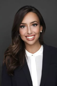 a smiling woman in a black suit and white shirt