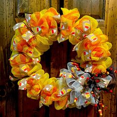 an orange and yellow mesh wreath on a wooden door